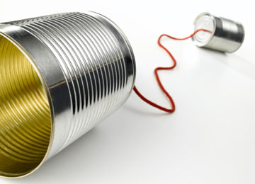 Two tin cans are connected together with string to make a simple telephone communications device